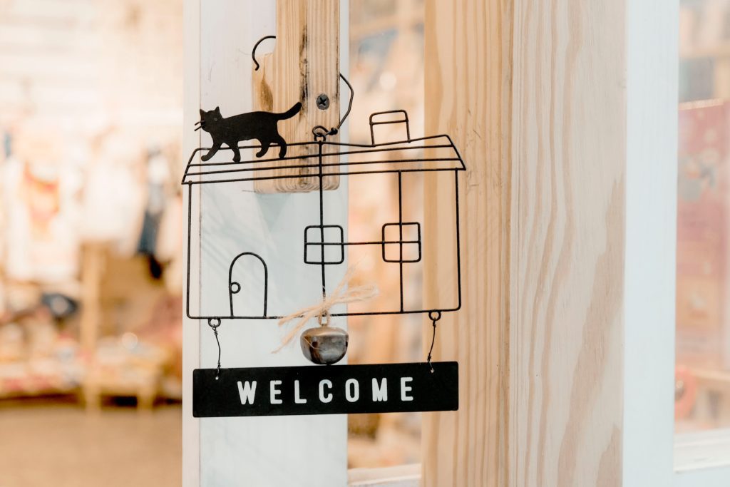 welcome sign with the image of a house, a cat and the word welcome