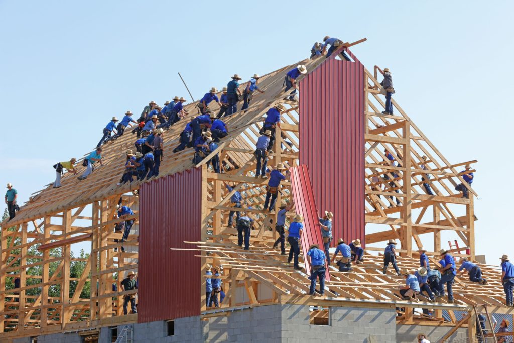 multiple people building a house together