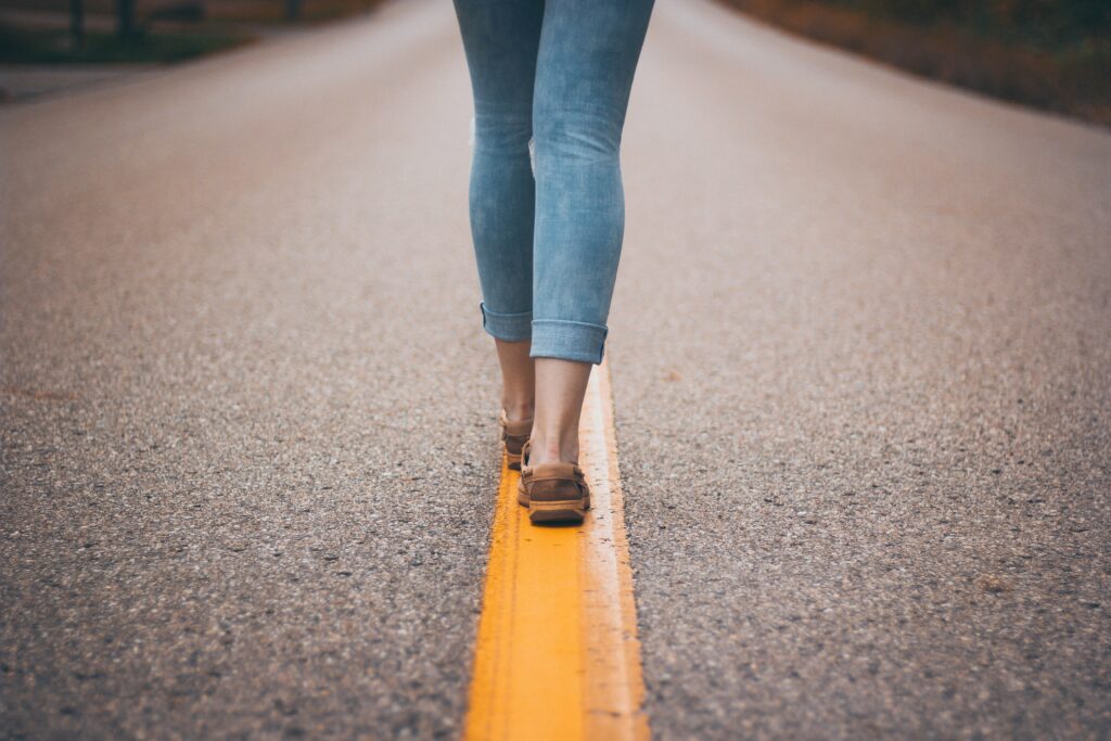 woman walking along a line in the road