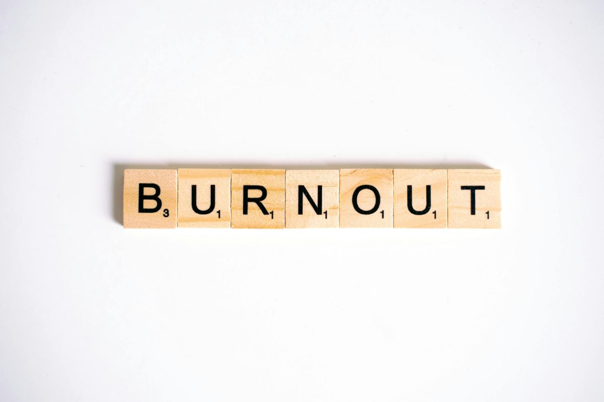 White background, wooden letter scrabble tiles spelling the word BURNOUT
