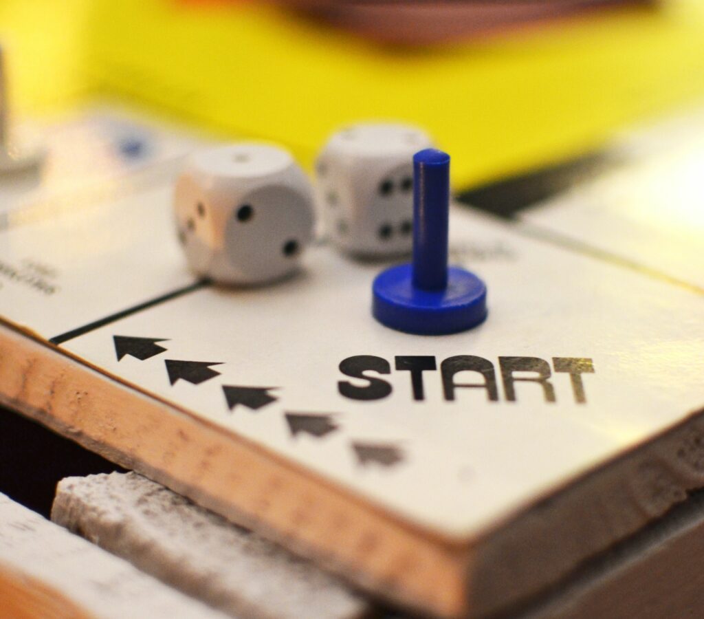 Board games board with a start square with a blue playing token and two dice