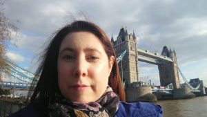 Serena, a white woman with brown hair, standing in front of London Tower Bridge.